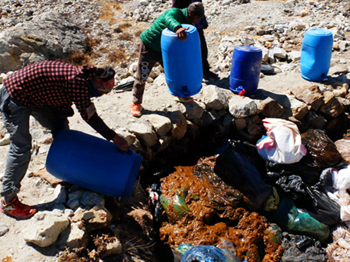 Porters Emptying Toilet Drums Onto The Ground